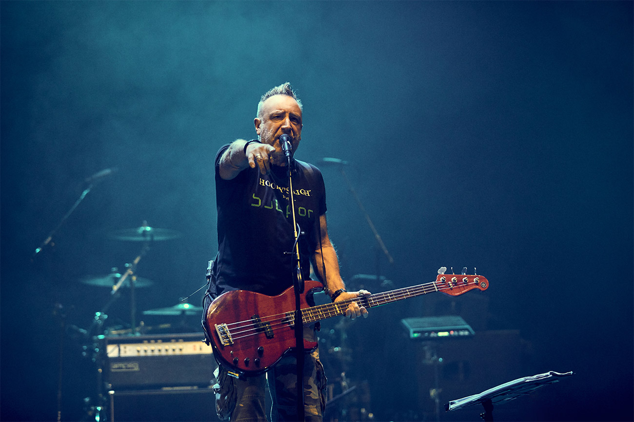 Peter Hook playing bass and singing on stage