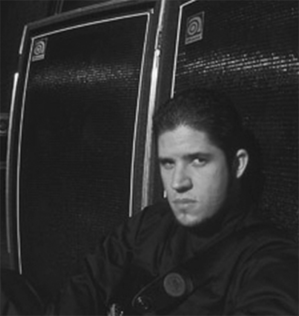 Tobin Esperance sitting in front of Ampeg cabs