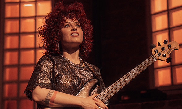 Pops Magellan on stage holding her bass