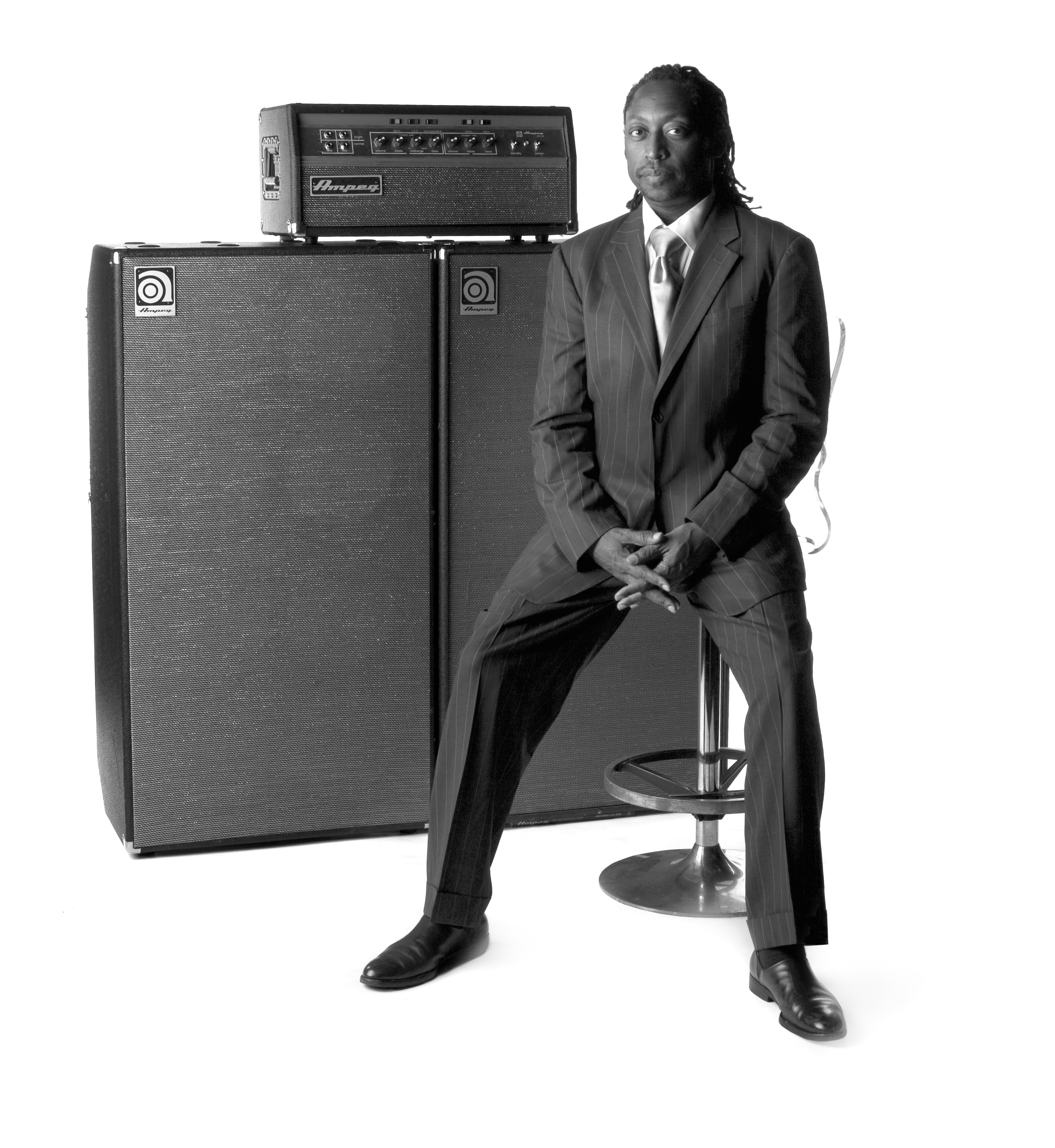 Darryl Jones sitting on a chair in front of Ampeg stack